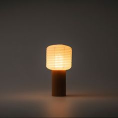 a lamp that is on top of a wooden stand in the middle of a room