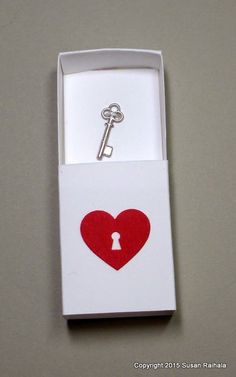 an open box with a key in the shape of a heart