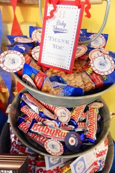 a three tiered tray filled with candy and candies next to a sign that says baby shower thank you