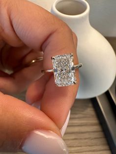 a close up of a person holding a diamond ring