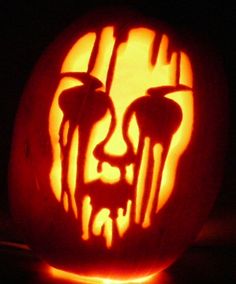 a pumpkin carved to look like the face of a man with blood dripping from his mouth