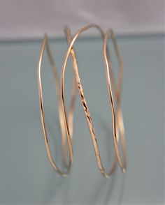 "This organic shaped bangle is an all in one stack. I hand made this piece from 14k gold filled round wire combining two diameters of wire and two textures, hammered and smooth. Because each one is individually made for you, each one will have its own special one of a kind character. Also available in Sterling Silver and Rose Gold Filled. Choose from a 2 1/2\" (small/med) or 2 3/4\" (med/large) diameter. If you require a special size, larger or smaller, simply leave a note in the message to sell Yellow Gold Wire Wrapped Bangle, Elegant 14k Gold Hand Wrapped Jewelry, Elegant Hand-wrapped 14k Gold Jewelry, Elegant Hand Wrapped 14k Gold Jewelry, Gold Wire Wrapped Bangle, Gold Hand Wrapped Hoop Jewelry, Bangle Stack, The Bangles, Stacked Bangles