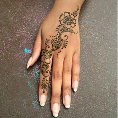 a woman's hand with henna tattoos on it