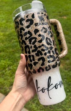 someone is holding up a leopard print coffee cup