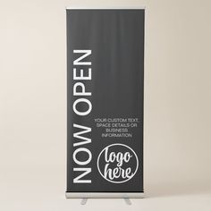 a black and white roll up banner with the words now open on it's side