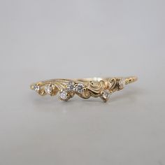 a yellow gold ring with five diamonds on the bottom and two smaller stones in the middle