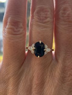 a woman's hand with a ring on it and a blue stone in the middle