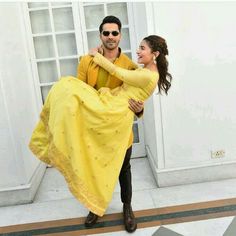 a man and woman dressed in yellow posing for the camera with their arms around each other