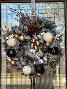 a christmas wreath with ornaments hanging from it's side in front of a window