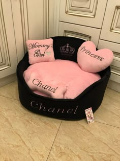 a black and pink dog bed with pillows