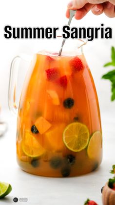 a pitcher filled with fruit and garnished with a spoon in it that says summer sangria