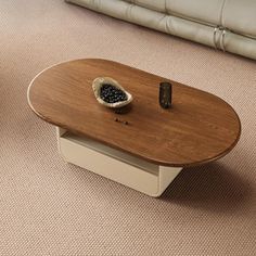 a living room with a couch, coffee table and two remotes on the floor