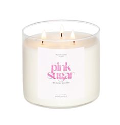 the pink sugar candle is in a clear glass container