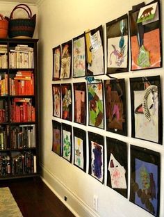 there are many pictures on the wall and bookshelves in this room, all decorated with children's artwork