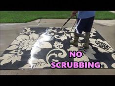 a person using a mop to spray paint on a flowered area rug with the words no scrubbing