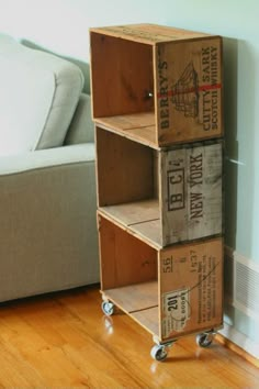 three wooden crates stacked on top of each other in front of a couch and wall