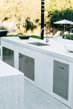 an outdoor kitchen with stainless steel appliances and sink