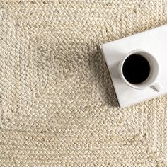 a cup of coffee sitting on top of a rug