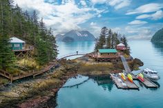 two boats are docked in the water next to a small island with a house on it