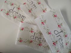 four pieces of cloth with the words dream and dreams printed on them, sitting on a table