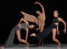 three dancers in black and grey pose for the camera