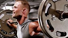 a man holding a barbell in the gym