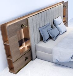 a bed that has pillows on it and a night stand in front of the headboard