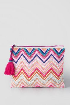 a pink and blue clutch bag with tassels on the front, zippered