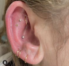 a close up of a person's ear with three different piercings on it