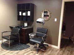 a salon room with chairs, desk and mirror on the wall in front of it