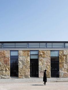 a person standing in front of a stone building