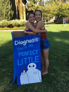 two girls hugging each other in front of a sign that says diagnosis you're the perfect little