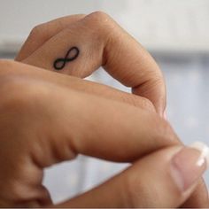 a person with a tiny tattoo on their finger