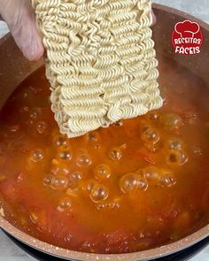 a person is stirring some noodles in a pot