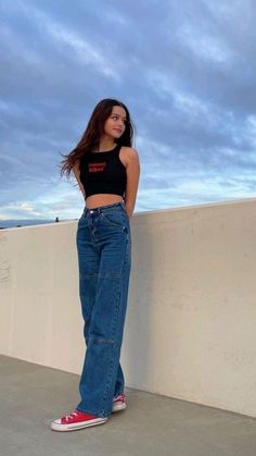 a woman standing on top of a cement wall