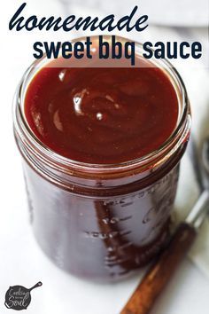 homemade sweet bbq sauce in a glass jar with cinnamon sticks on the side and text overlay