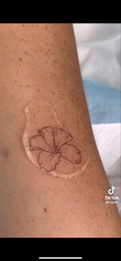 a woman's arm with a tattoo on it that has a flower in the middle