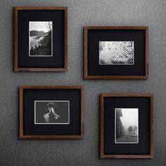 four black and white photographs hanging on a wall next to two wooden frames with pictures in them