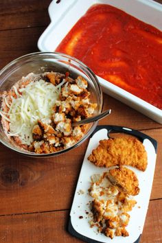 some food is laying out on a wooden table next to a bowl of tomato sauce