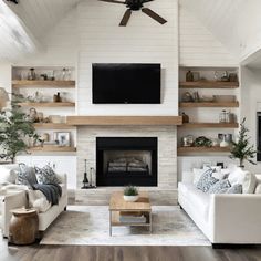 a living room filled with furniture and a flat screen tv mounted on the wall above a fire place