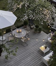 an overhead view of a deck with tables and chairs, umbrellas and flowers on it