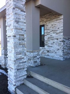 a building with some steps leading up to the front door and side entrance, which is made out of stacked blocks