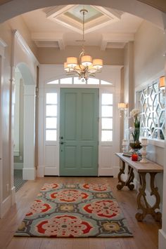 an entryway with a green door and rug on the floor in front of it