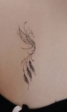 the back of a woman's stomach with an artistic tattoo design on her left side