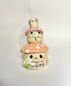 three ceramic figurines stacked on top of each other with flowers in the middle