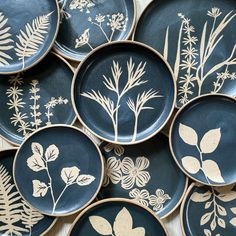 many plates with designs on them are arranged in the shape of flowers and leaves,