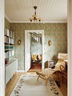 a living room filled with furniture and a rug on top of a hard wood floor