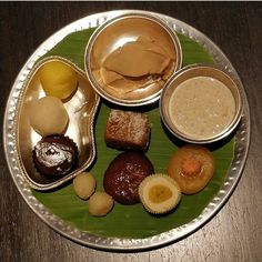 an assortment of desserts on a plate sitting on top of a wooden table,