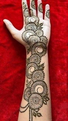 a woman's hand with henna tattoos on it