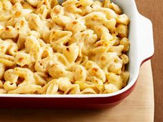 macaroni and cheese in a red casserole dish on a wooden table